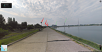 Imagine de pe Google Maps, din 2016, cu Lacul Morii (Lacul Dâmbovița): săgețile roșii din imagine marchează stâlpii de iluminat cu panouri fotovoltaice (de pe dig), iar săgețile verzi marchează două puncte de reper pentru locul pozat: un reper este podul hobanat peste Dâmbovița, aflat în construcție (se vede doar stâlpul principal în depărtare), al doilea reper este clădirea albă cu roșu, cu mai multe etaje.